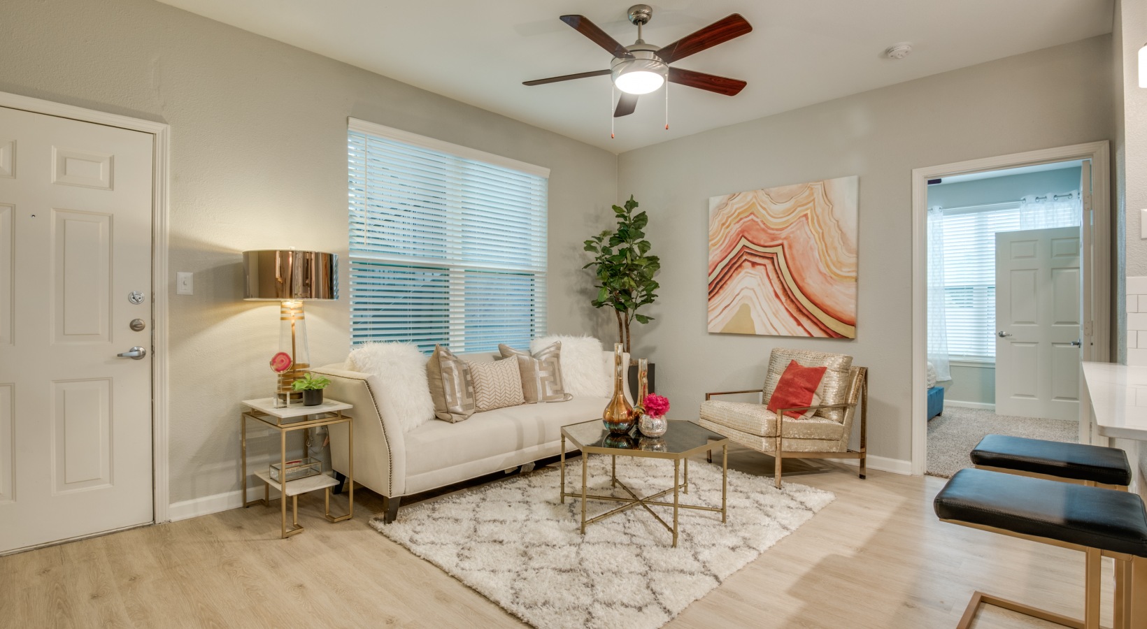 a living room with a ceiling fan and white walls at The  Sophia