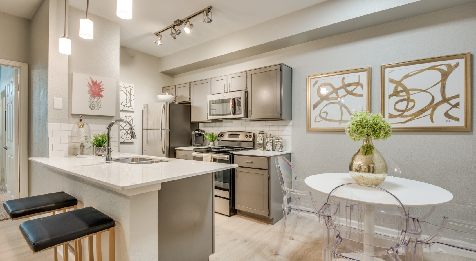 a kitchen with white cabinets and stainless steel appliances at The  Sophia