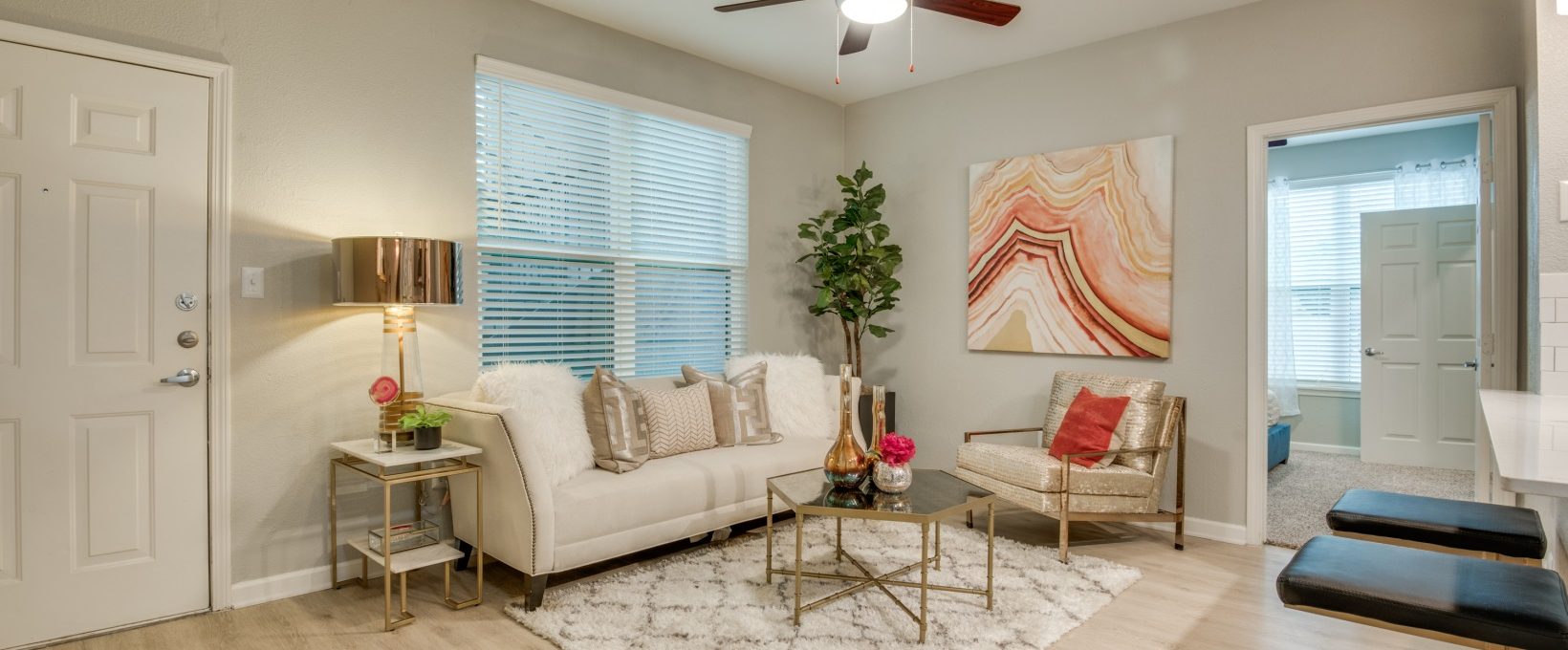 a living room with a ceiling fan and white walls at The  Sophia